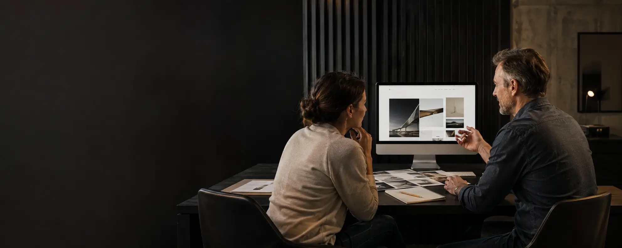 Two collaborators reviewing a website and printed page layouts together